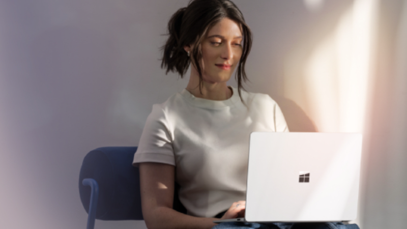 Woman using a Microsoft Surface laptop.
