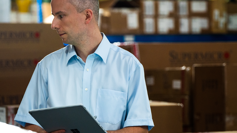 A man in a warehouse working with a tablet in his hand