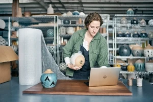 a person sitting at a table in front of a laptop