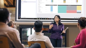 A group watching a businesswoman give a presentation.