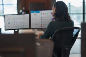 A person sitting at a desk using headset.