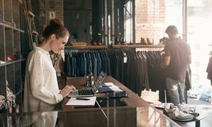 A young woman in front of her clothing boutique