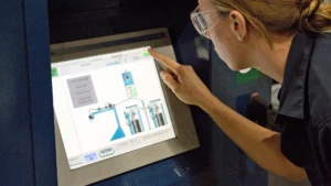 Person in safety glasses touching a monitor