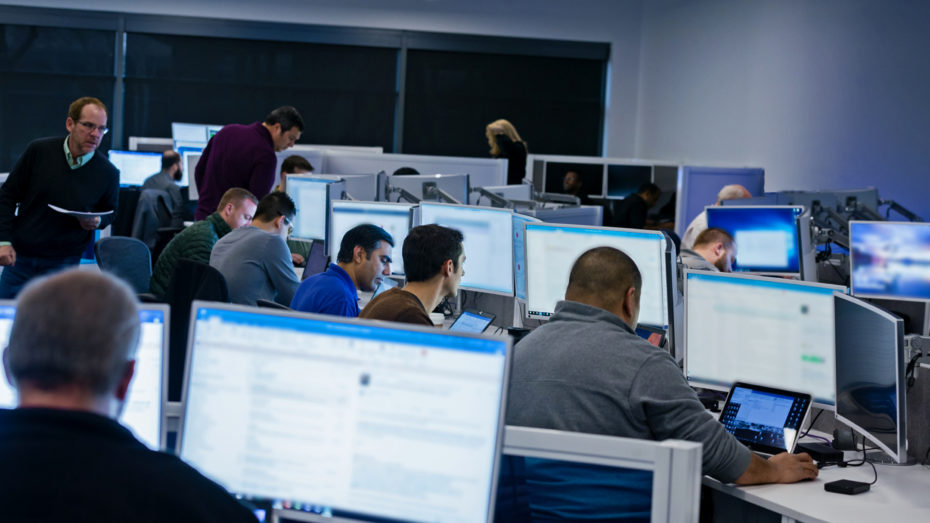 Group of people sitting at desks working in an office.