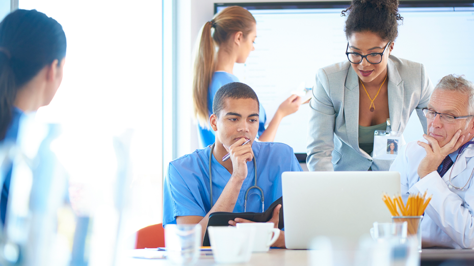 Image of doctors and nurses surrounding a laptop.