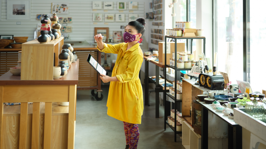 Retail employee with mask reviewing inventory for a curbside pickup order in Excel on OneDrive.