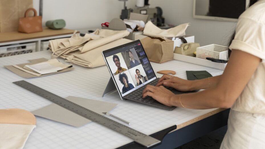 Contextual photography of adult female inside using Surface Pro X to participate in Microsoft Teams call.