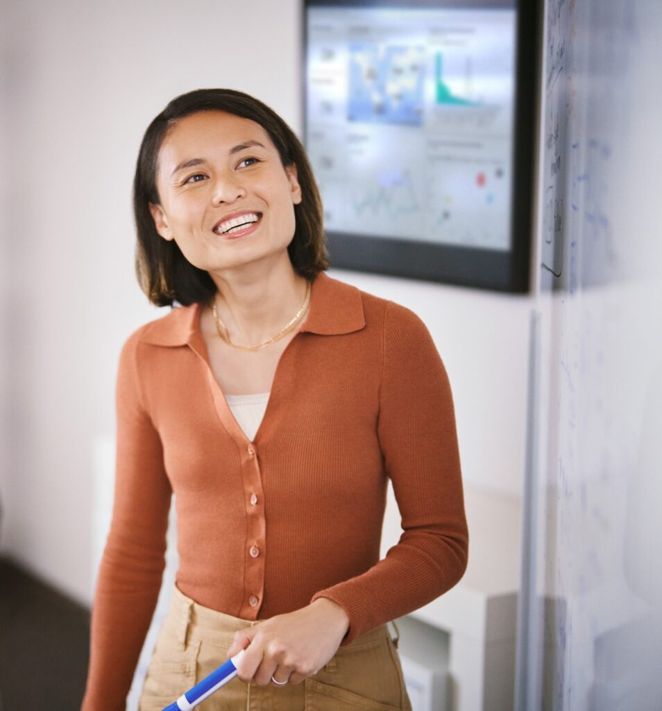 Developer engaged in a white board session collaborating with colleagues.