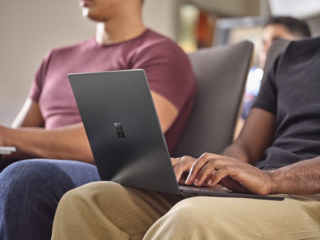 Adult male typing on laptop in lap.