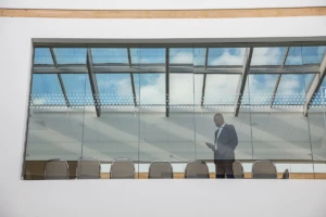 Photo of a man in a meeting room using phone.