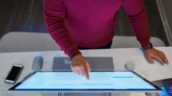 A security practitioner points at a computer screen.