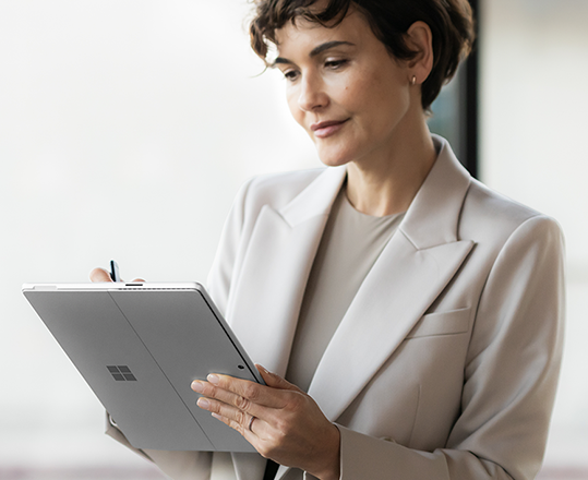 Mujer con blazer usando una tableta Microsoft Surface.