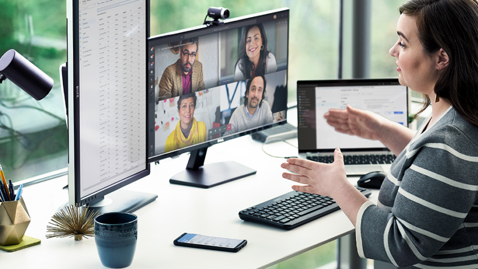 Image of a woman running a meeting from her desk.
