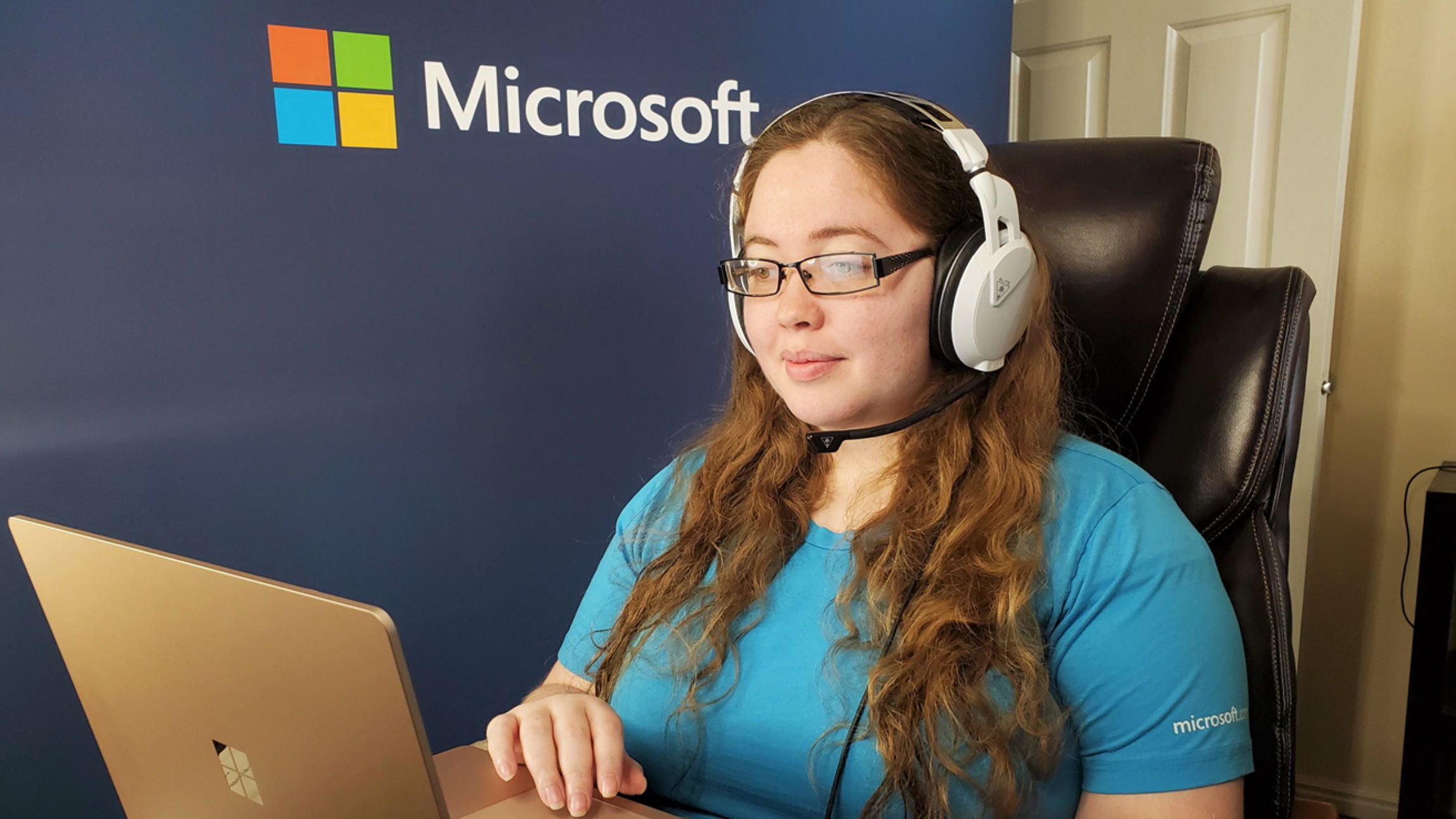 Chelsea Cox sits at her home office and talks to a customer on her laptop.