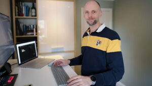 Fraser Murrell stands at his computer in his home office.