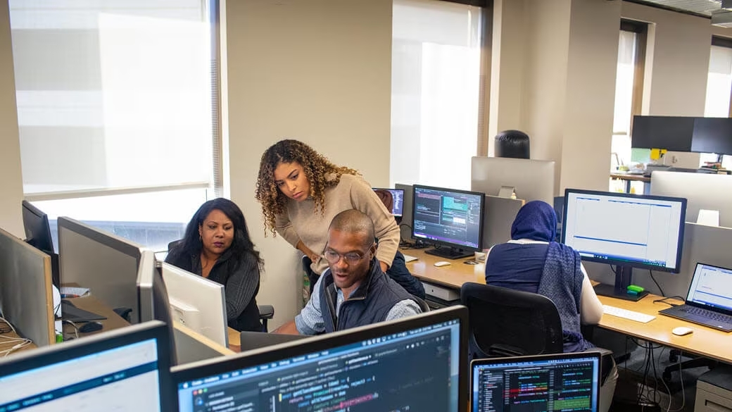 Developer manager collaborates with developer in enterprise developer work space.