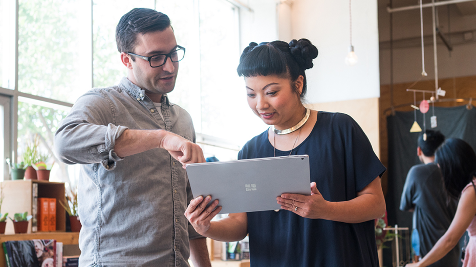 Image of two firstline workers collaborating over a laptop.